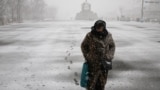A woman makes her way through heavy snow fall at Gyeongbok palace in central Seoul, South Korea, Feb. 6, 2025. 