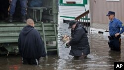 A man walks with his dog to a National Guard vehicle after leaving his flooded home in Moonachie, New Jersey, after Hurricane Sandy