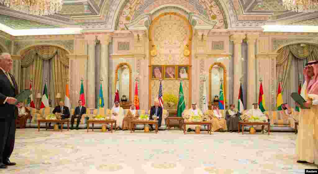 Presiden AS Donald Trump (tengah) memperhatikan Menteri Luar Negeri AS Rex Tillerson (kiri) dan Putra Mahkota Arab Saudi Muhammad bin Nayef (kanan) bertukar nota kesepakatan saat KTT para pemimpin Dewan Kerjasama kawasan Teluk di Riyadh, 21 Mei 2017.