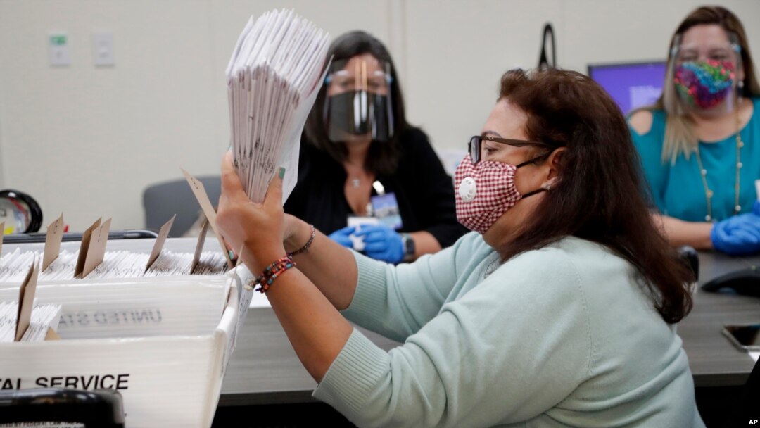 La trabajadora del Departamento de Elecciones de Miami-Dade, Elizabeth Romero, ordena boletas de votación enviadas para las primarias del 18 de agosto.