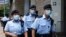 Police stand guards as a prison van arrive High Court on the first day of trial of Tong Ying-kit, the first person charged under a new national security law, in Hong Kong, June 23, 2021.
