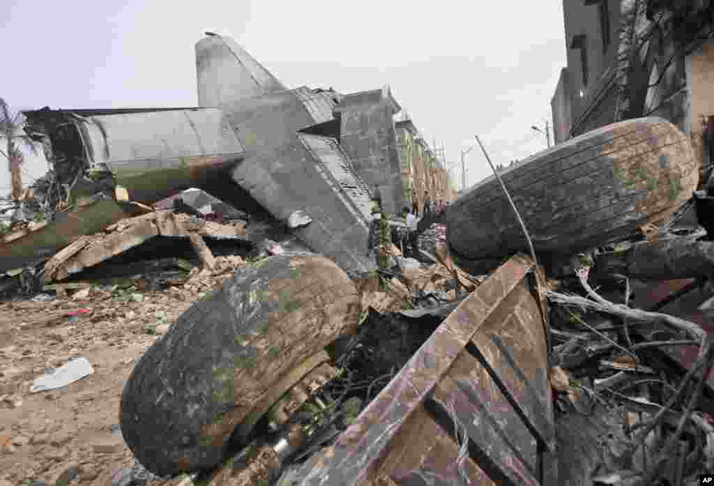 Para petugas mencari korban di lokasi jatuhnya pesawat Hercules C-130B di Medan (1/7). (AP/Yudha Lesmana)