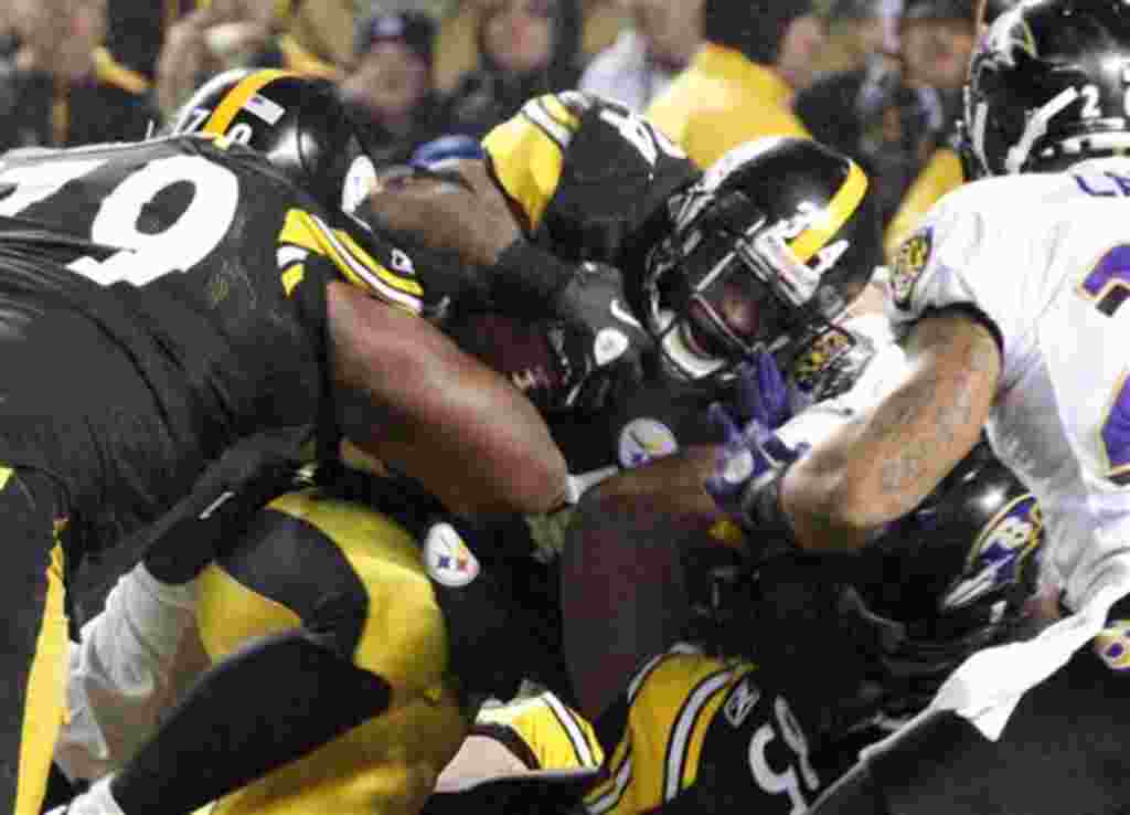 Steelers y Ravens pelean por conseguir la posesión de la pelota en el partido jugado entre ambos equipos.