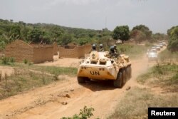 United Nations peacekeeping force vehicles drive by houses destroyed by violence in September, in the abandoned village of Yade, Central African Republic, April 27, 2017.