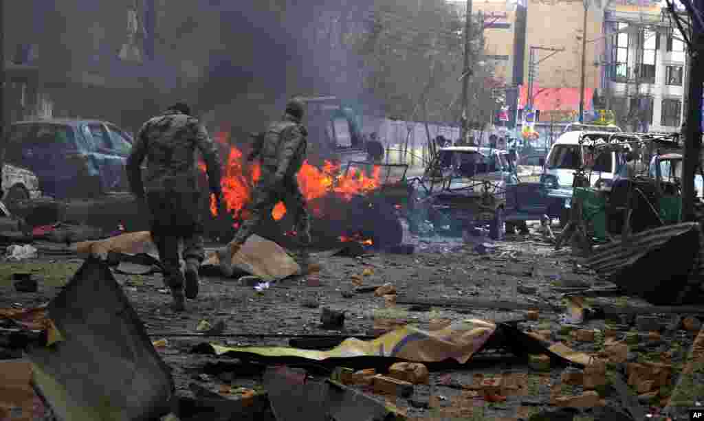 شبه نظامیان از یکی از مناطق بمب گذاری شده در شهر کویته دیدن می کنند. شبه نظامیان بلوچ در کویته مرکز ایالت بلوچستان پاکستان با دولت مرکزی مخالفند- ۱۴ مارس ۲۰۱۴