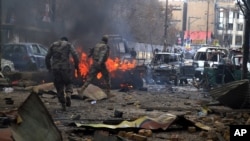 FILE - Paramilitary soldiers visit an area hit by a bomb attack, claimed by a Taliban splinter group, in Quetta, Pakistan, March 14, 2014.