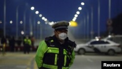 Cảnh sát thi hành phận sự tại một chốt chặn trên chiếc cầu bắc ngang qua Sông Dương Tử tới Hồ Bắc, Trung Quốc, giữa vụ bộc phát dịch viêm phổi cấp do chủng virus mới nCoV. REUTERS/Thomas Peter