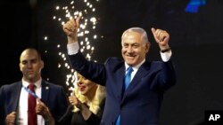 Umushikiranganji wa mbere wa Isirayeli Benjamin Netanyahu aramutsa abamuyoboka inyuma y'aho ibiro vy'amatora vyugaye i Tel Aviv, Isirayeli, 10/04/2019.