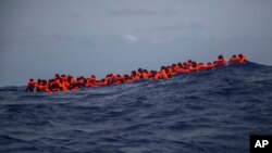 Migrants wait to be rescued by aid workers of Spanish NGO Proactiva Open Arms in the Mediterranean Sea, about 15 miles north of Sabratha, Libya, July 25, 2017. More than 120 migrants were rescued Tuesday from the Mediterranean Sea while many — including pregnant women and children — died in a crammed rubber raft, according to a Spanish rescue group. 