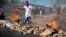A civilian jumps over a burning barricade of rocks erected by residents to protect themselves from police, in a northern district of the capital Bujumbura, in Burundi, May 14, 2015. 