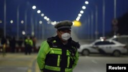 Un agente de policía chino custodia el 30 de enero de 2020 una barrera en un puente sobre el río Yangtzé hacia la provincia de Hubei, donde apareció el brote de coronavirus.