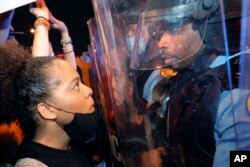 یک تظاهرکننده و یک افسر پلیس در اعتراضات در نیواورلئان به یکدیگر خیره شدند. ۳ ژوئن ۲۰۲۰