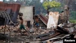 Anak anak Rohingya warga desa di pinggiran Maugndaw, negara bagian Rakhine mencari barang-barang dari rumah-rumah yang hangus dibakar akhir Oktober lalu (foto: dok).