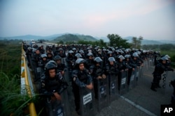 Kordon policajaca u opremi za razbijanje demonstracija blokira put kako bi zaustavio karavan hiljada centralnoameričkih migranata da dalje prođu ka gradu Ariega, Čiapas, meksiko, 27. oktobra 2018.