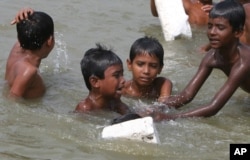 In Bangladesh many children swim in potentially unsafe water to escape the heat, May 2007, outskirts of Dhaka, Bangladesh. (AP Photo)