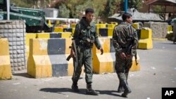 Policemen stand guard at the entrance of the now-closed U.S. Embassy in Sanaa, Yemen, Feb. 11, 2015.