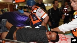 Wounded Israeli policeman is evacuated from the scene of an attacked in Beersheba, Israel, Sunday, Oct. 18, 2015. ( AP Photo/Dudu Grunshpan)