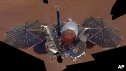 En esta imagen de la NASA, del 6 de diciembre de 2018, se ve a la sonda InSight posada en suelo de Marte. La imagen fue conformada con 11 imágenes tomadas con el brazo robot del aparato.