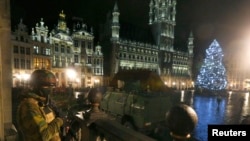 A Belgian soldier stands guard at the Grand Place of Brussels as police searched the area during a continued high level of security following the recent deadly Paris attacks, in Brussels, Belgium, Nov. 22, 2015.