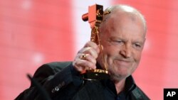 FILE - British singer Joe Cocker receives the lifetime achievement award for music during the 48th Golden Camera award ceremony in Berlin, Germany, Feb. 2, 2013.