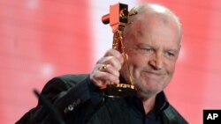 FILE - British singer Joe Cocker receives the lifetime achievement award for music during the 48th Golden Camera award ceremony in Berlin, Germany, Feb. 2, 2013.