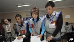 Members of local electoral committee sort through a ballot box, at a polling station in Bishkek, Kyrgyzstan, 10 Oct. 2010.