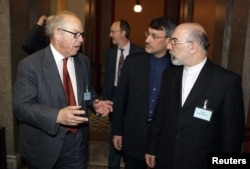 Iran's Ambassador to Finland Javad Kajoyan Fini and the Director of the Ministry of Foreign Affairs of Iran Hamid Baeidinejad (second from right) talk to the former chief U.N. Weapons inspector Hans Blix in Helsinki, April 7, 2005.