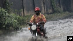 A man ride on motor cycle through a flooded street following a heavy downpour in Lagos, Nigeria, July 11, 2011