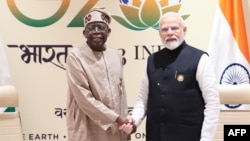 Perdana Menteri India Narendra Modi (kanan) dan Presiden Nigeria Bola Ahmed Tinubu berjabat tangan selama pertemuan bilateral setelah sesi penutupan KTT G20 di New Delhi pada 10 September 2023. (Foto: AFP)