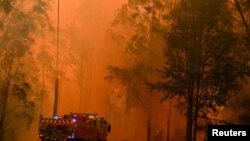 FILE - Firetrucks respond to a bushfire in Werombi, 50 kilometers southwest of Sydney, Dec. 6, 2019.