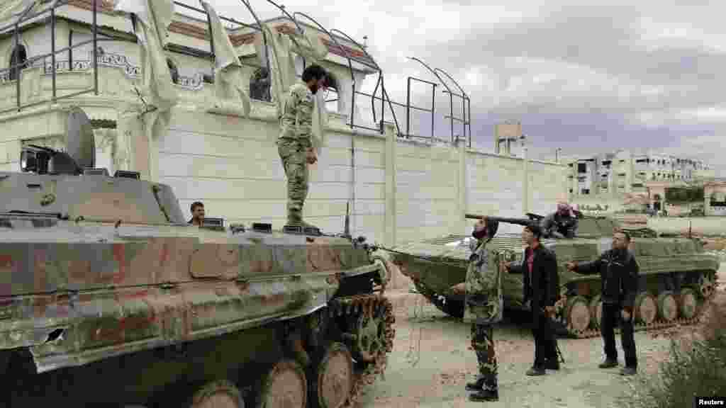 A Free Syrian Army fighter stands atop an armored personnel carrier captured from forces loyal to Syrian President Bashar al-Assad, Aleppo, March 4, 2013.