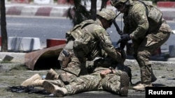 U.S. soldiers attend to a wounded soldier at the site of a blast in Kabul, Afghanistan June 30, 2015. (REUTERS/Omar Sobhani)