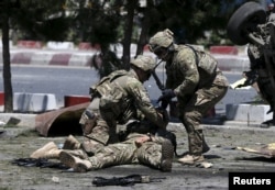 FILE - U.S. troops attend to a wounded soldier at the site of a blast in Kabul, Afghanistan, June 30, 2015. In an open letter, the Taliban has called on the Trump administration to abandon the war in Afghaistan, calling it “futile” and “unwinnable.”