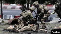 FILE - U.S. soldiers attend to a wounded soldier at the site of a blast in Kabul, Afghanistan June 30, 2015. 