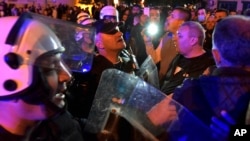 Montenegrin police officers block protesters in Niksic, Montenegro, May 13, 2020. Protests in support of eight detained priests continued May 14, 2020.