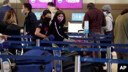 Viajeros en fila para registrar equipaje en el Aeropuerto Internacional Los Angeles, el miércoles 23 de diciembre de 2020.