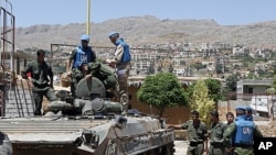 United Nations (U.N.) observers examine a Syrian army tank during a field visit to the al-Zabadani area, near Damascus, May 6, 2012. Al-Zabadani is one of the locations where protests against the regime of Syrian President Bashar al-Assad were being held.