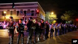 Policías con trajes antimotines forman una línea de contención durante las protestas en San Luis, Missouri.