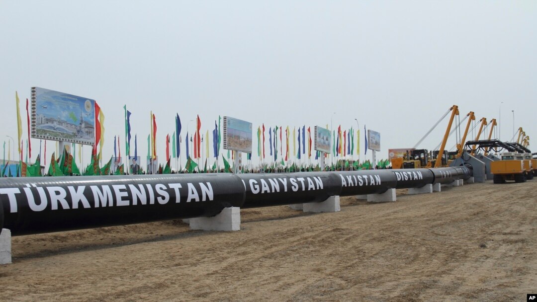 FILE - Workers at the Turkmen-Afghan border prepare to weld the first link crossing the frontier during the integration ceremony of the pipeline in Serhetabat, Turkmenistan, Feb. 23, 2018.