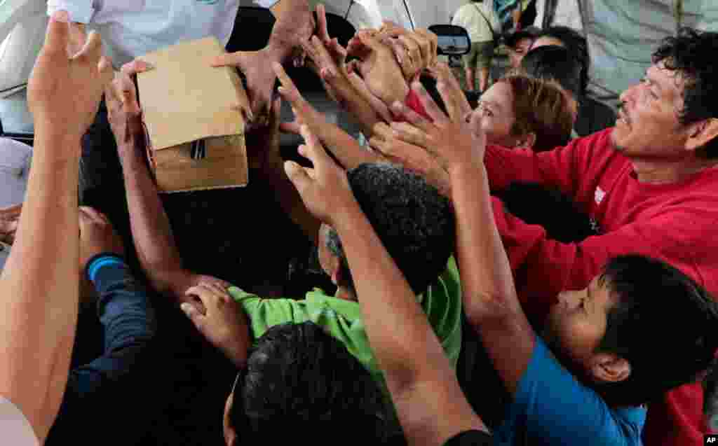 A person distributes food to hurricane victims under a bridge in San Pedro Sula, Honduras, Nov. 21, 2020.