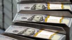 FILE - Cut stacks of $100 bills make their way down the line at the Bureau of Engraving and Printing Western Currency Facility in Fort Worth, Texas, Sept. 24, 2013. 