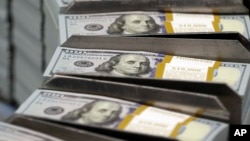 FILE - Cut stacks of $100 bills make their way down the line at the Bureau of Engraving and Printing Western Currency Facility in Fort Worth, Texas, Sept. 24, 2013. 