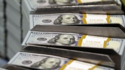 FILE - Cut stacks of $100 bills make their way down the line at the Bureau of Engraving and Printing Western Currency Facility in Fort Worth, Texas, Sept. 24, 2013. 