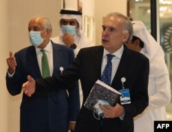 US special envoy for Afghanistan Zalmay Khalilzad (L) and the United Nations Secretary-General's personal envoy on Afghanistan Jean Arnault walk down a hotel lobby in Doha during an international meeting, Aug. 10, 2021.