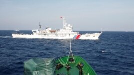 A ship (top) of the Chinese Coast Guard is seen near a ship of the Vietnam Marine Guard in the South China Sea, about 210 km (130 miles) off shore of Vietnam, May 14, 2014.