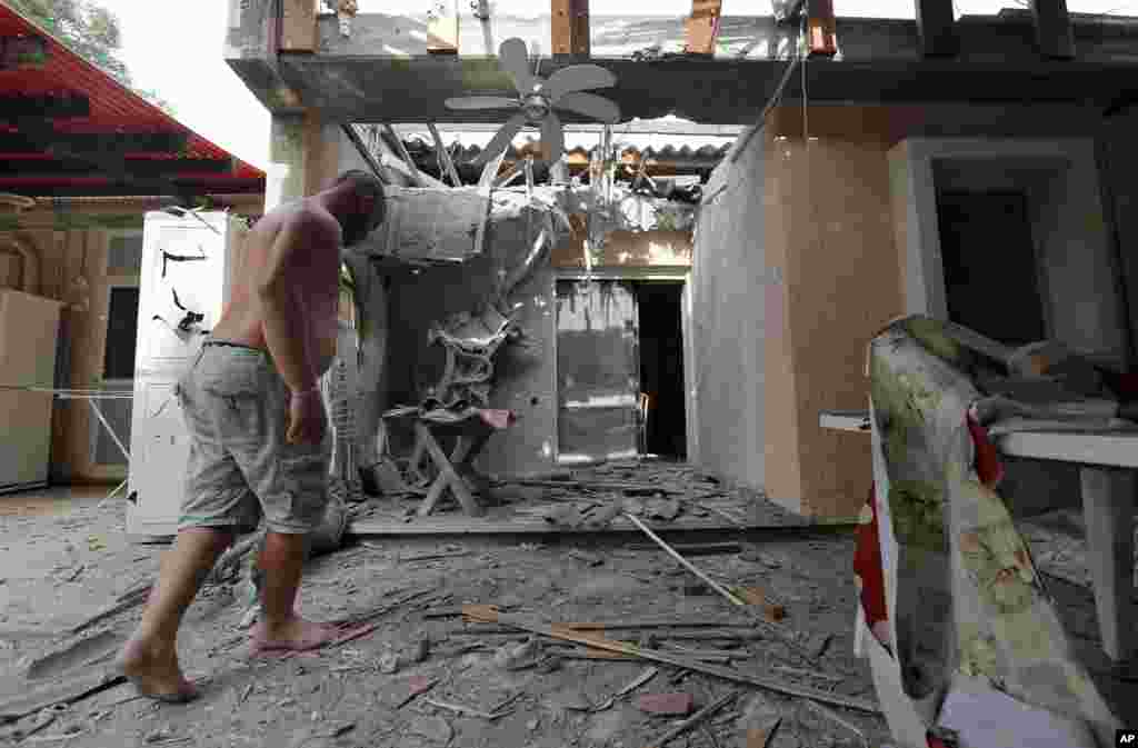 An Israeli man enters a damaged house after a rocket fired by Palestinian militants from Gaza Strip hit a community in southern Israel, October 24, 2012.
