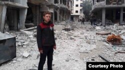 Muhammed Najem stands in the rubble of his neighborhood in Arbin, Eastern Ghouta, Feb. 23, 2018.