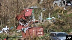 FILE - Homes lay scattered after the passing of Hurricane Maria in Roseau, the capital of the island of Dominica, Sept. 23, 2017.