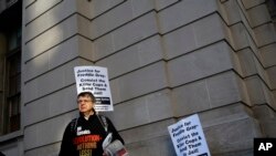 Un manifestante protesta afuera de la corte en Baltimore, donde un jurado delibera sobre el caso de William Porter, uno de seis policías acusados de la muerte del prisionero afroestadounidense Freddie Gray. Dic. 15, 2015.