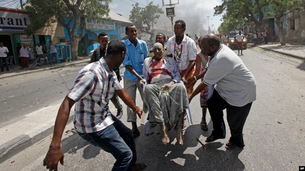 Rescuers carry away a man who was wounded in a car bomb attack in Mogadishu, Somalia, March 13, 2017.